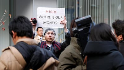 Kolin Burges, a self-styled cryptocurrency trader and former software engineer from London, holds up a placard to protest against Mt Gox, in front of the building where the digital marketplace operator was formerly housed in Tokyo, in 2014. Reuters