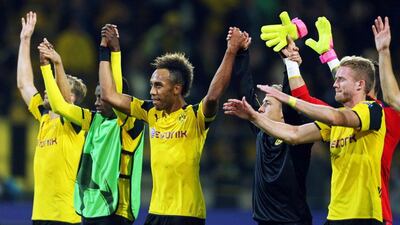 Borussia Dortmund players Pierre-Emerick Aubameyang, centre, and Andre Schurrle, right, celebrate with fans after the Champions League Group F match. Ina Fassbender / EPA