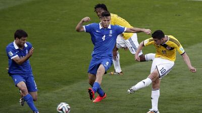 Colombia midfielder James Rodriguez scores his side's third goal in a 3-0 win over Greece on Saturday at the 2014 World Cup. Adrian Dennis / AFP