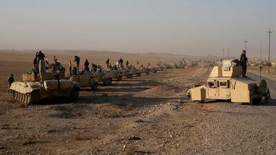 Iraqi soldiers stand on top of armoured vehicles before clashes with ISIL fighters in Al-Qasar, South-East of Mosul.