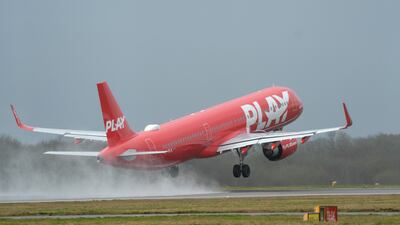 A plane takes off from a wet Stansted Airport in Essex. PA