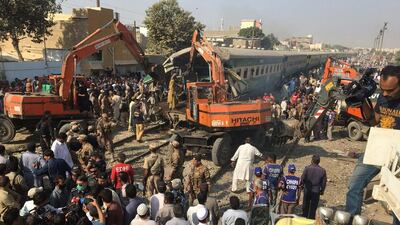 Rescuers workers use heavy machinery to move a carriage after two trains collided in Karachi, Pakistan, on November 3, 2016. Akhtar Soomro / Reuters