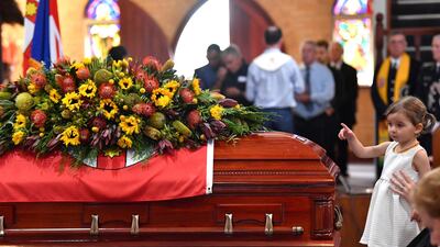 Charlotte O'Dwyer, the daughter of Rural Fire Service volunteer Andrew O'Dwyer, stands in front of her father's casket during the funeral at Our Lady of Victories Catholic Church in Horsley Park, Sydney. Reuters