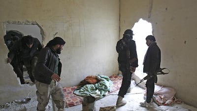 Members of Islamist Syrian rebel group Jabhat Al Nusra carry their weapons as they move through a hole in a wall near Aleppo international airport on January 28. Ammar Abdullah/Reuters