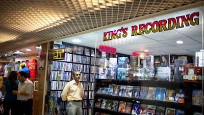 The salesman and right-hand man Muin Hasan takes a break in restocking merchandise at King's Recording in the Hamdan Centre.