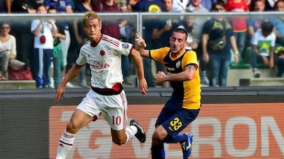 AC Milan's Keisuke Honda dribbles away from Verona defender Alessandro Agostini during Milan's Serie A victory on Sunday in Verona. Giuseppe Cacace / AFP / October 19, 2014