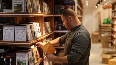 A worker arranges bookshelves ahead of the opening of the new Samir Mansour bookshop that was destroyed during last year's 11-day war between Israel and the Palestinian Hamas movement, in Gaza City.