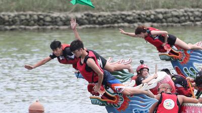 A boat leader tries to grab the finish line flag during the traditional Chinese dragon boat race in Taipei, Taiwan. AP Photo