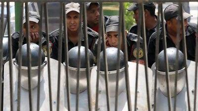 Egyptian security forces stand behind the gates of Cairo’s parliament building as they await protesters.