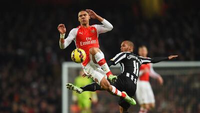 Kieran Gibbs of Arsenal challenges for the ball with Yoan Gouffran of Newcastle United during their Premier League contest on Saturday. Paul Gilham / Getty Images