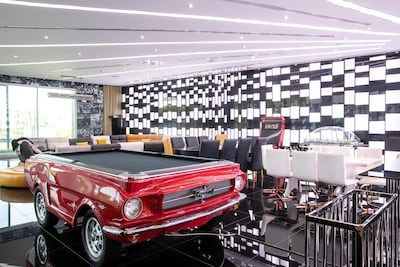 The games room was designed to be a dynamic space, with hidden lighting that can turn it into a nightclub or another cinema with giant projector screens that drop down from the ceiling. Antonie Robertson/The National