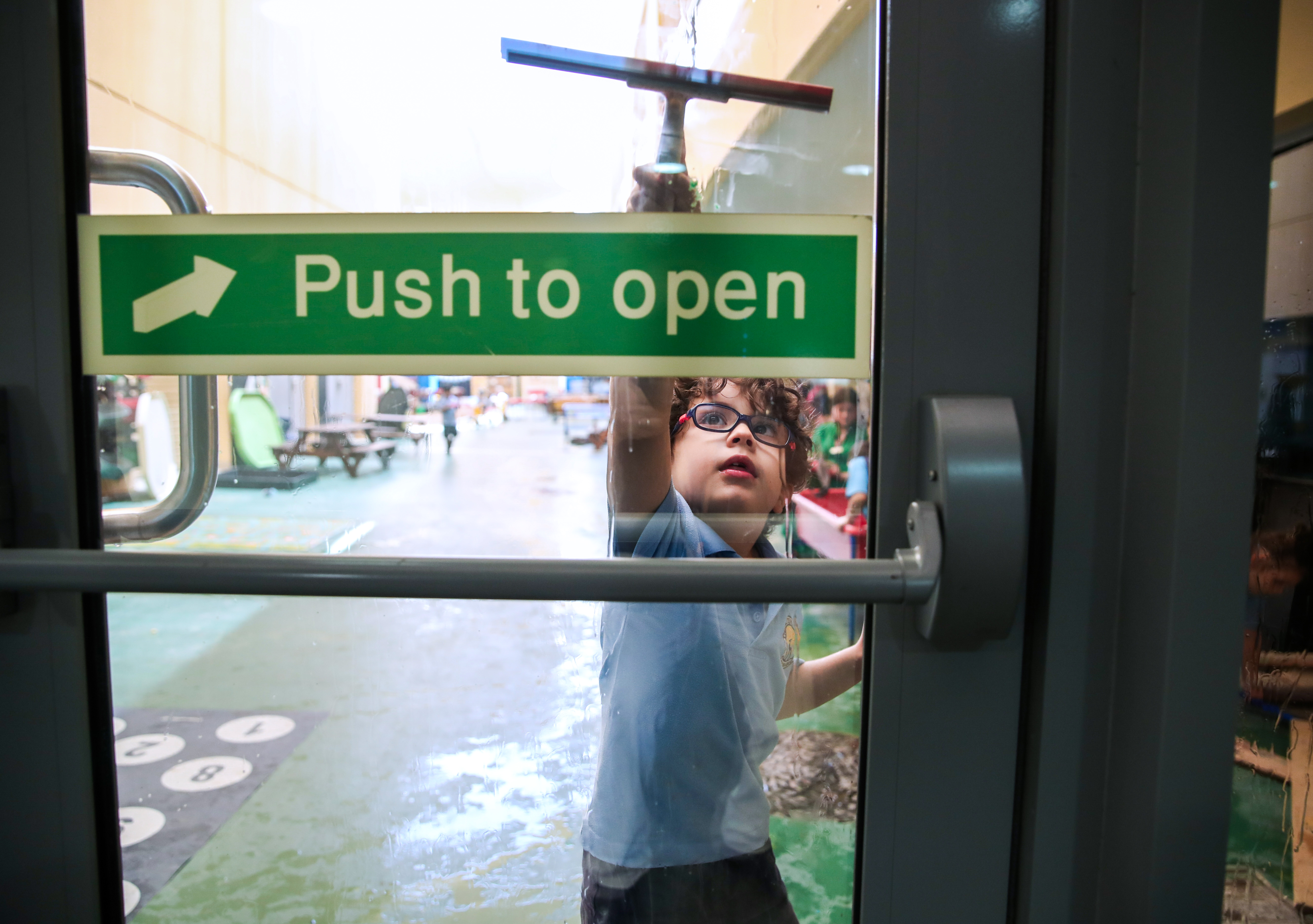 A pupil helps to clean the play area at British School Al Khubairat.