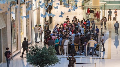 Customers in Dubai Mall queued through the night to be one of the first to get their hands on Apple's new iPhones. Leslie Pableo / The National