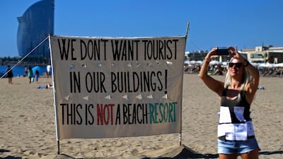 A woman takes a picture during a protest against tourism in Barcelona on August 12, 2017. Manu Fernandez / AP