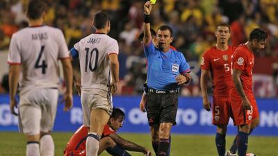 El Salvadorean referee Joel Aguilar (C) shows the yellow card to Colombia's James Rodriguez (2-L) during a Copa America Centenario semifinal football match against Chile in Chicago, Illinois, United States, on June 22, 2016. / AFP / Tasos Katopodis