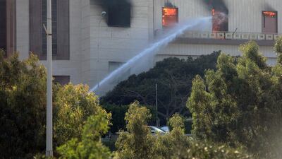 Firemen hose down a burning building of the headquarters of Libya's foreign ministry after suicide attackers hit in Tripoli. Reuters