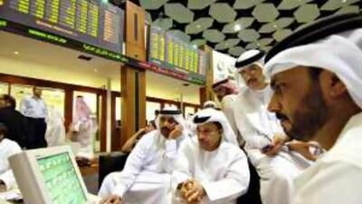 Dubai low, sell high: Men look over a quote screen on the floor of the Dubai Financial Market.