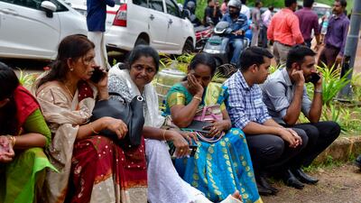 Jehovah's Witnesses wait outside the Zamra International Convention Centre after the explosion. AP