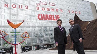 French president Francois Hollande, right, and the president of the Arab World Institute in Paris, Jack Lang, at institute yesterday. The centre’s building carried the message ‘We are Charlie’. Ian Langsdon / EPA
