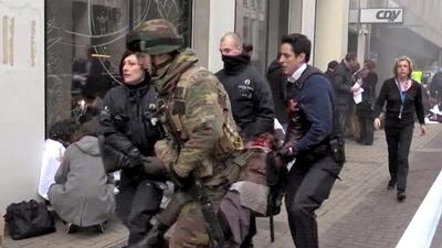 A television grab shows Belgian policemen and a soldier carrying an injured person after an explosion at the Maelbeek Metro station in Brussels on March 22, 2016. EPA