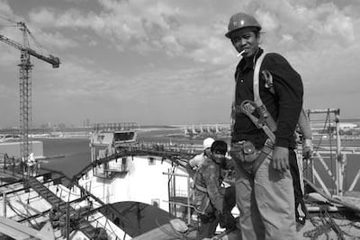 Rene Padirayon on top of the main arch in autumn 2009. Work on the Sheikh Zayed Bridge helped thousands of employees build better lives for the families they had left behind to go to work. Courtesy Roy Lengweiler