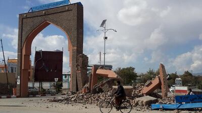 A man rides his bicycle next to damaged buildings in Ghazni, Afghanistan. Reuters