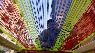 A Pakistani artisan makes a traditional woven bed, known as a charpai, at a workshop in the northern city of Peshawar. EPA