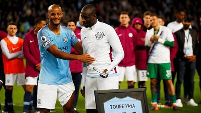 Manchester City's Yaya Toure is presented with a shirt by Vincent Kompany. Jason Cairnduff / Reuters