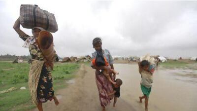 A woman and her children evacuate before Cyclone Mahasen was set to land at a Rohingya refugee camp outside of Sittwe, Myanmar.