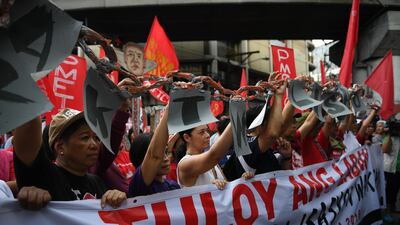 Activists along with workers hold a mock chain as they march towards Malacanang Palace during the May Day rally in Manila. Ted Aljibe / AFP