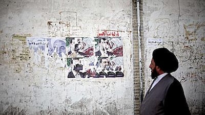 An Iranian clergyman walks past electoral posters of presidential candidates in Qom, some 130 kilometres south of the capital Tehran.
