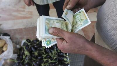 A vendor counts Syrian currency notes in Damascus. Muzaffar Salman / Reuters