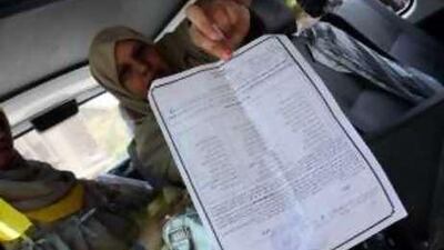 Nadia Omar holds a paper she says gives her and other women permission to be an observer inside the polling station. She says election officials at the el Tebin polling station refused to allow her to enter.