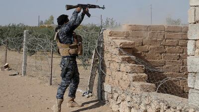 A member of Iraqi special forces police fires rifles during clashes with ISIL. Goran Tomasevic / Reuters