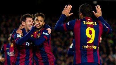 Lionel Messi, left, celebrates with Barcelona teammates Neymar, centre, and Luis Suarez, right, after the second of his three goals on Sunday night. His 21 hat-tricks leave him two shy of Cristiano Ronaldo's present record of 23. Alex Caparros / Getty Images