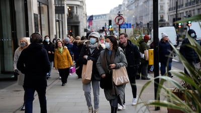 In Britain, mask-wearing in shops and on public transport will be required from Tuesday in attempt to staunch Omicron's spread. AP