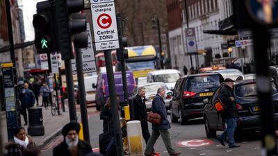 Signs indicating London congestion charges that drivers pay for entering the capital's central areas, which British financial services group Capita operates, are pictured on the streets of central London on February 1, 2018. The share price of British financial services group Capita plunged more than 40 percent on January 31, 2018, after the indebted outsourcing firm warned over future profits. / AFP PHOTO / Tolga Akmen