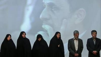 Family members of Iran's slain nuclear scientists and the chief of Iran's Atomic Energy Organization, Fereidoun Abbasi, right, in a ceremony marking Iran's National Day of Nuclear Technology, with president Mahmoud Ahmadinejad in the background.