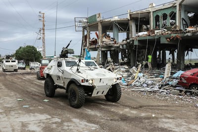 Peacekeepers of the UN Interim Force in Lebanon drive past the destroyed healthcare centre in Burj Qalawiya. AFP