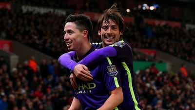 Samir Nasri of Manchester City celebrates with teammate David Silva after scoring City's fourth goal in their win over Stoke. Alex Livesey / Getty Images