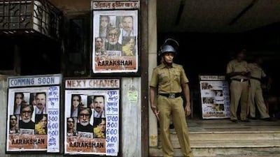 Policemen stand guard outside a cinema hall screening the just- released film "Aarakshan," in Mumbai, on Friday. Three Indian states have banned the movie following fears that certain scenes may trigger trouble. Rajanish Kakade / AP Photo
