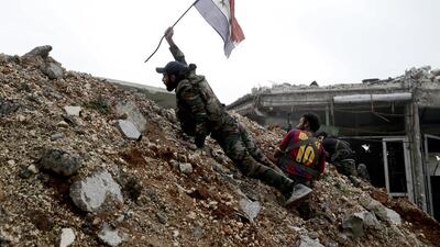 A government soldier places a Syrian national flag during a battle with rebel fighters at the Ramouseh front line, east of Aleppo, on December 5, 2016. Hassan Ammar, File / AP Photo