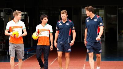 Nico Hulkenberg and Sergio Perez of Formula One team Force India walk onto Whitten Oval in Melbourne with Australian rules football players Shaun Higgins and Will Minson. Darrian Traynor / Getty Images / March 11, 2014