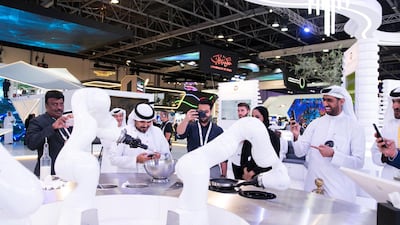 People take photos of a robot preparing a crepe during Gitex Technology Week at Dubai World Trade Centre. Reem Mohammed/The National