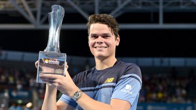 Milos Raonic holds the men's singles trophy after defeating Roger Federer at the Brisbane International . Bradley Kanaris / Reuters