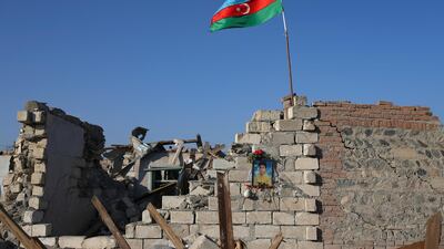 A portrait of a person killed during the conflict hangs outside a house in Ganja, Azerbaijan, that was destroyed by rocket fire from Armenian forces. AP