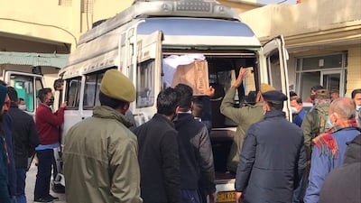 Policemen help to load coffin of a victim of a stampede from community health centre in Katra, near Jammu, India, Jan. 1, 2022. A stampede at a popular religious Hindu shrine has killed at least 12 people and injured 12 others on New Year's Day in Indian-controlled Kashmir early Saturday, officials said. Authorities were investigating what caused the stampede at Mata Vaishnav Devi shrine where tens of thousands of Hindu devotees assemble daily to pay their obeisance in hilly Katra town near southern Jammu city. (AP Photograph / Channi Anand)