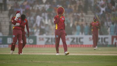 West Indies' players cover their faces as they leave the field after a dust storm during the third ODI against Pakistan at the Multan Cricket Stadium. AP
