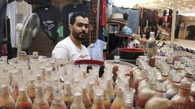 Artisan Nadim Tantawi crafts a decorative sand bottle at his stand in the empty visitors center at Jerash, Jordan on October 21, 2020