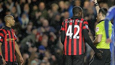 Referee Mark Clattenburg, right, shows a red card to Manchester City's Gael Clichy, left.